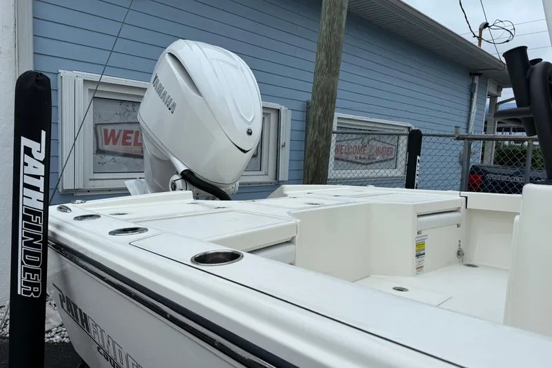 Slide: The Image of 2026 Pathfinder 2500 Hybrid boat with Yamaha engine, docked near a blue building. - 10