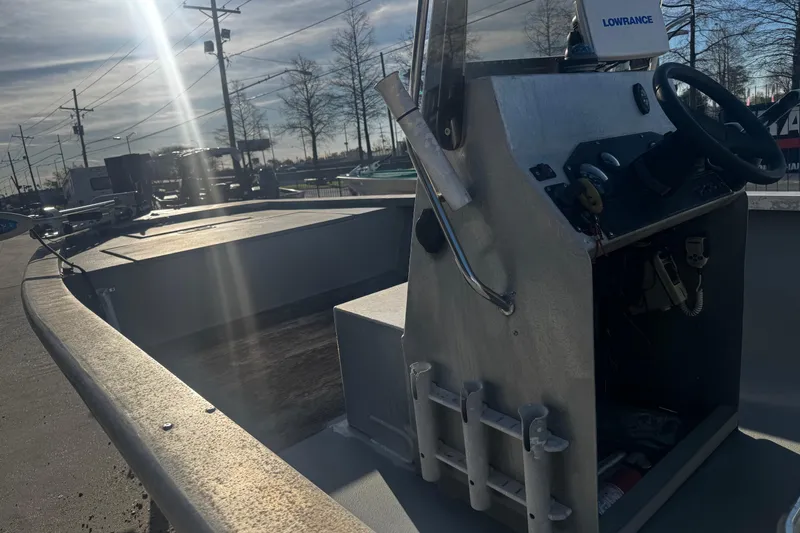 Slide: The Image of Aluminum boat with steering console, Lowrance equipment, and rod holders, under a sunny sky. - 17