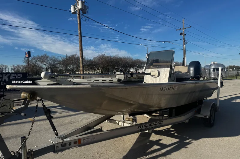 Slide: The Image of Custom Charles Leonard 21 boat on trailer, 2004 model, parked outdoors under clear blue sky. - 7