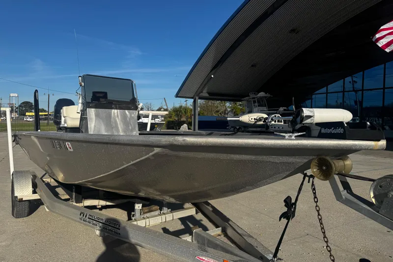 Slide: The Image of Custom Charles Leonard 21 boat on trailer, 2004 model, parked outdoors under clear blue sky. - 9
