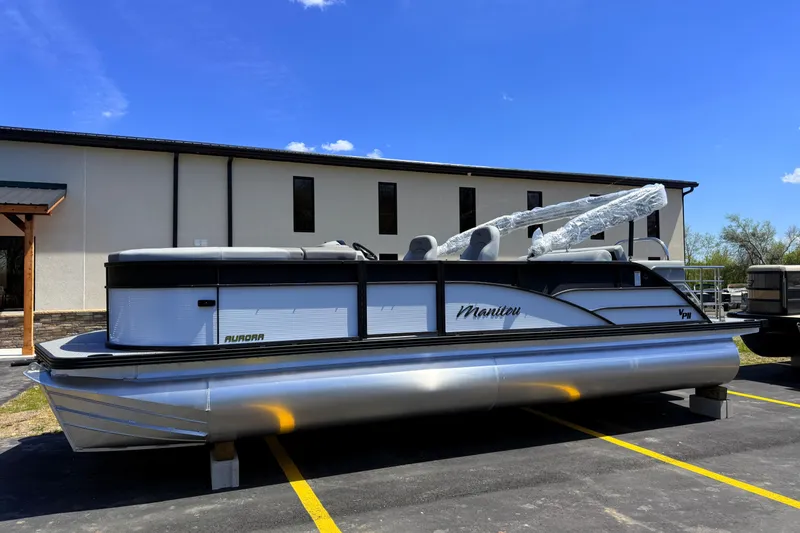 The Image of 2026 Manitou 23 Aurora SL VPII pontoon boat parked outdoors under clear blue sky. - 0