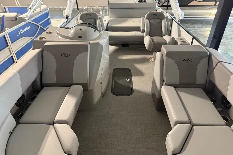 Slide: The Image of 2026 Manitou 23 Aurora SL VPII pontoon boat interior with gray seating and helm. - 12