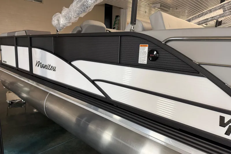 Slide: The Image of 2026 Manitou 23 Aurora SL VPII pontoon boat, sleek design, white and black exterior. - 2