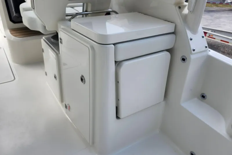 Slide: The Image of 2026 Pursuit DC 286 Dual Console interior, featuring sleek white cabinetry and seating. - 16