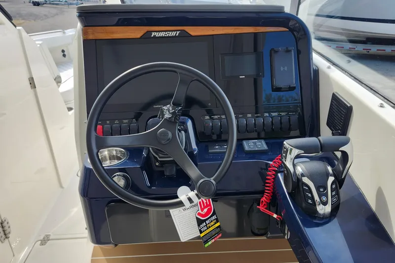 Slide: The Image of 2026 Pursuit DC 286 Dual Console boat dashboard with steering wheel and controls. - 23