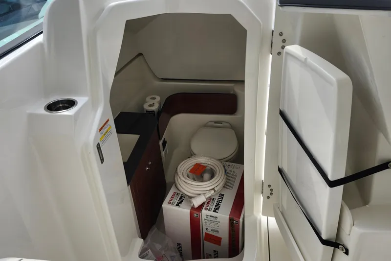 Slide: The Image of Interior of 2026 Pursuit DC 286 Dual Console boat with toilet and storage area. - 26