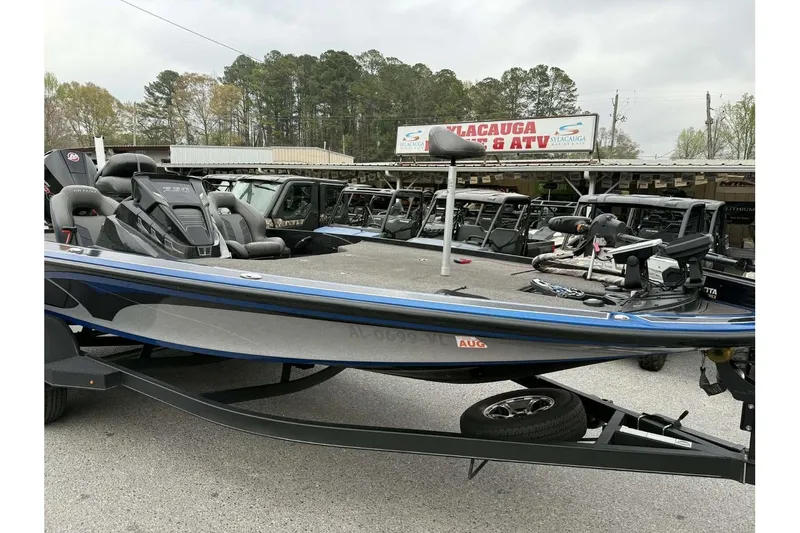 Slide: The Image of 2022 Nitro Z20 boat displayed at dealership with other vehicles in background. - 7