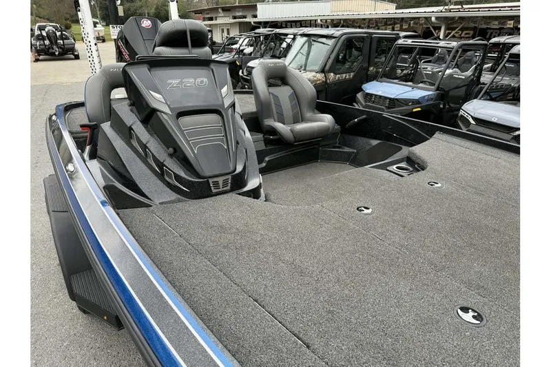 Slide: The Image of 2022 Nitro Z20 boat with spacious deck and sleek design, parked among other vehicles. - 9
