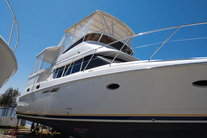 Slide: The Image of 1999 Silverton 422 Motor Yacht with sleek design against clear blue sky. - 101