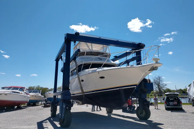 Slide: The Image of 1999 Silverton 422 Motor Yacht on lift under clear blue sky. - 103