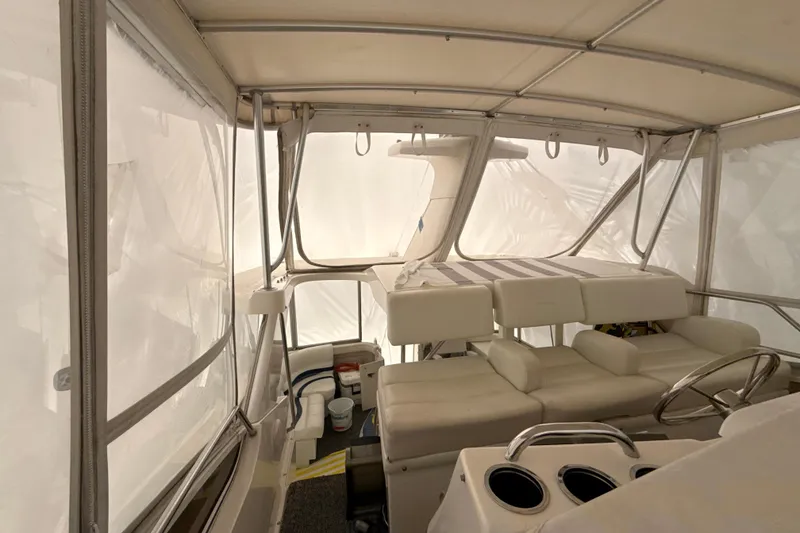 Slide: The Image of Interior view of a 1999 Silverton 422 Motor Yacht with white seating and helm. - 11