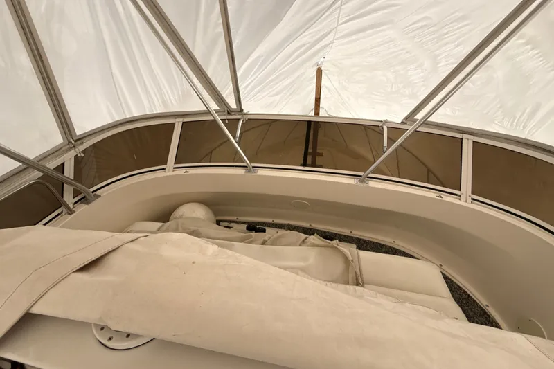 Slide: The Image of 1999 Silverton 422 Motor Yacht interior under protective cover, showcasing seating area. - 14