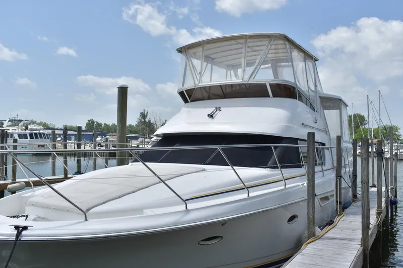 The Image of 1999 Silverton 422 Motor Yacht docked at marina under blue sky. - 0