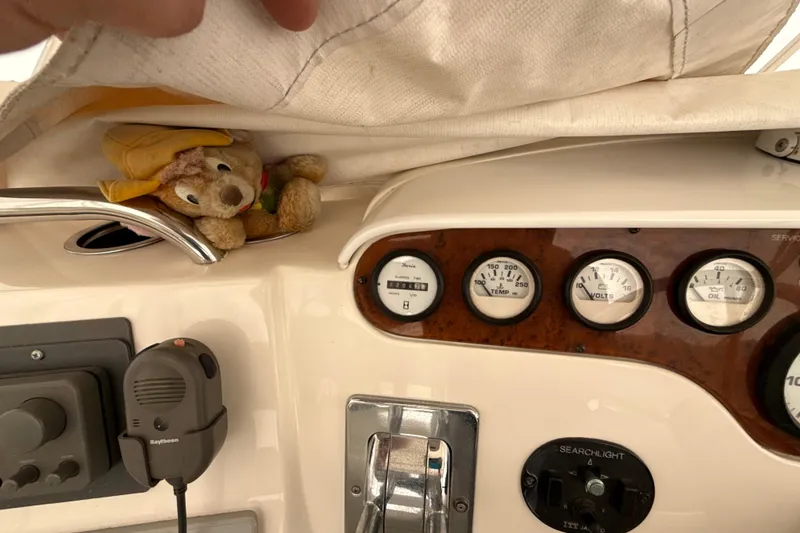 Slide: The Image of 1999 Silverton 422 Motor Yacht dashboard with gauges and a plush toy tucked under a cover. - 19