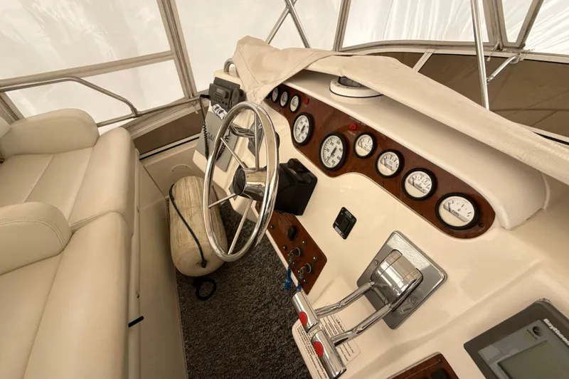 Slide: The Image of 1999 Silverton 422 Motor Yacht helm with steering wheel, gauges, and controls. - 21