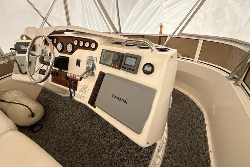 Slide: The Image of 1999 Silverton 422 Motor Yacht helm with Garmin navigation system and classic steering wheel. - 23