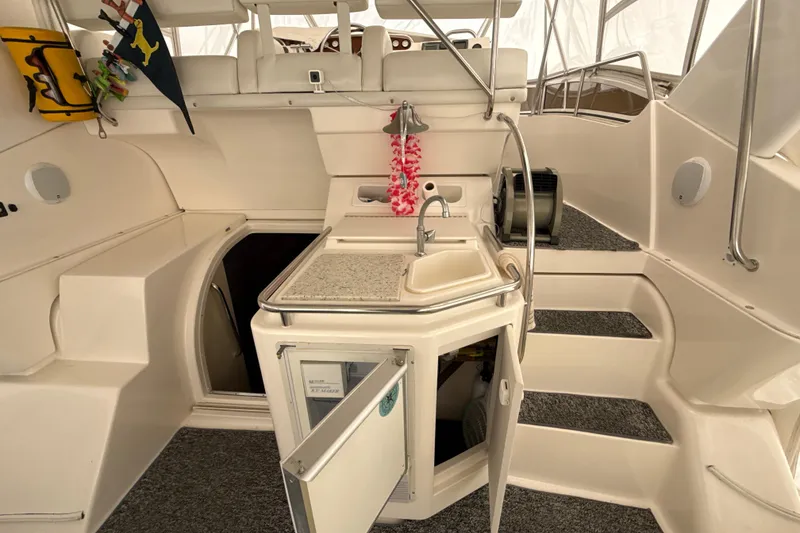 Slide: The Image of 1999 Silverton 422 Motor Yacht interior with sink, open cabinet, and seating area. - 27