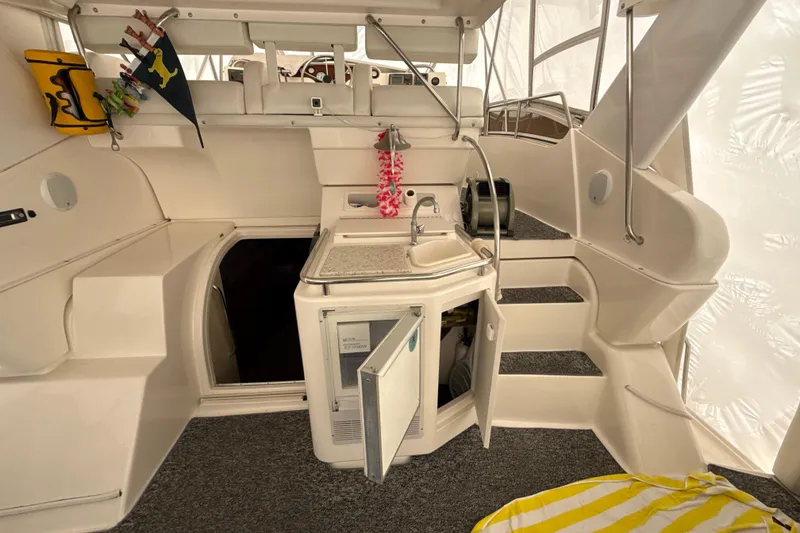 Slide: The Image of 1999 Silverton 422 Motor Yacht interior with kitchenette, open cabinet, and stairs. - 28