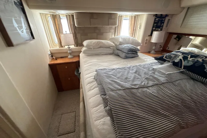 Slide: The Image of Cozy bedroom interior of 1999 Silverton 422 Motor Yacht with striped bedding and natural light. - 40