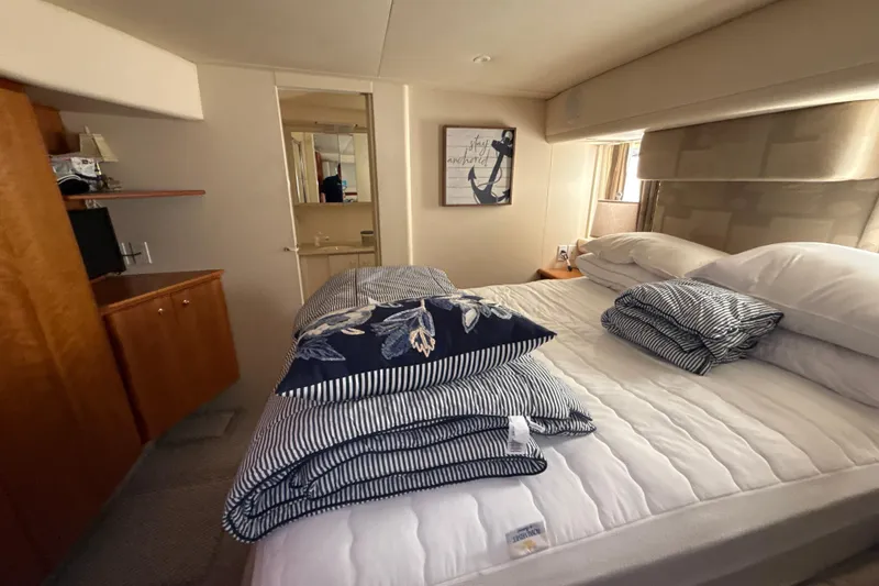 Slide: The Image of Cozy bedroom interior of 1999 Silverton 422 Motor Yacht with nautical decor and striped bedding. - 49