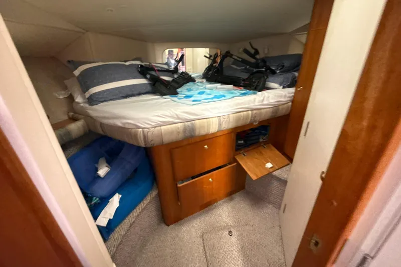 Slide: The Image of Cozy cabin interior of 1999 Silverton 422 Motor Yacht with bed and storage. - 60