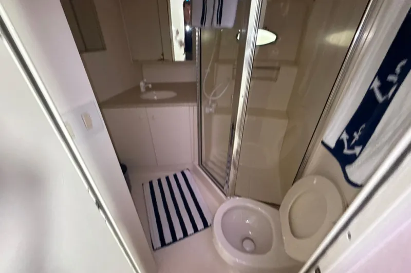 Slide: The Image of Bathroom interior of 1999 Silverton 422 Motor Yacht with shower and striped rug. - 62