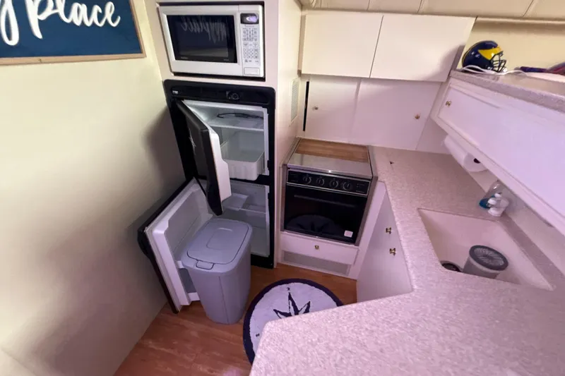 Slide: The Image of 1999 Silverton 422 Motor Yacht kitchen with microwave, fridge, and stove. - 67