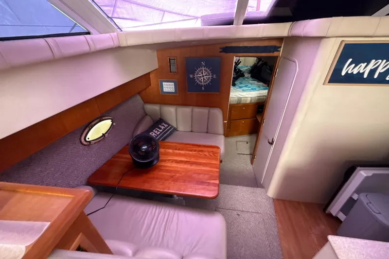 Slide: The Image of Interior of 1999 Silverton 422 Motor Yacht with cozy seating and wooden table. - 70
