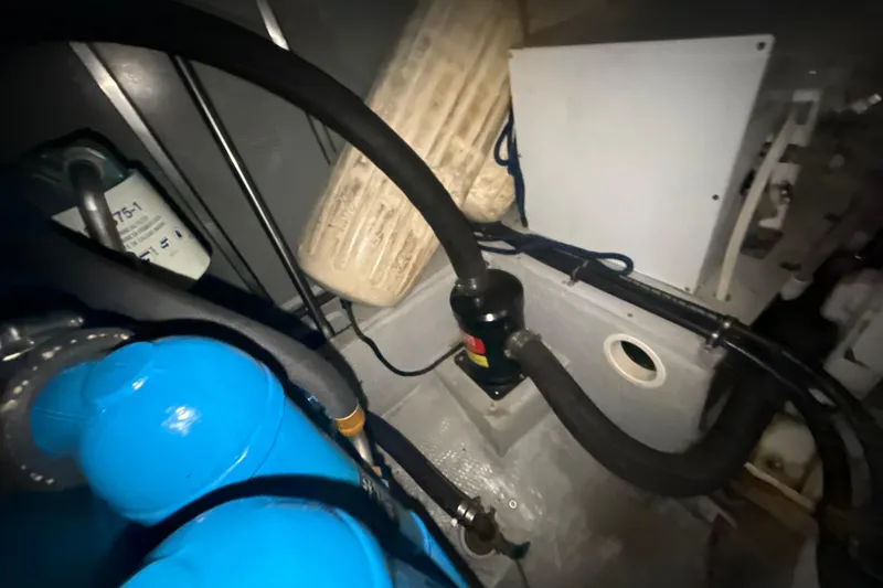 Slide: The Image of Engine room of a 1999 Silverton 422 Motor Yacht with visible hoses and equipment. - 74