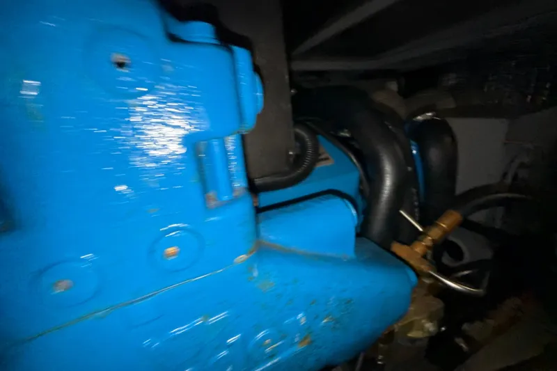 Slide: The Image of Engine compartment of a 1999 Silverton 422 Motor Yacht, featuring blue machinery components. - 77