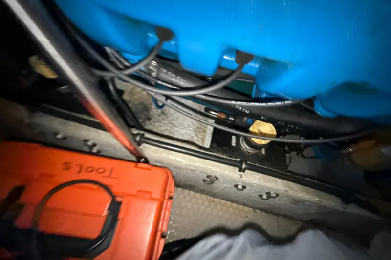Slide: The Image of Engine compartment of a 1999 Silverton 422 Motor Yacht with tools and cables visible. - 80