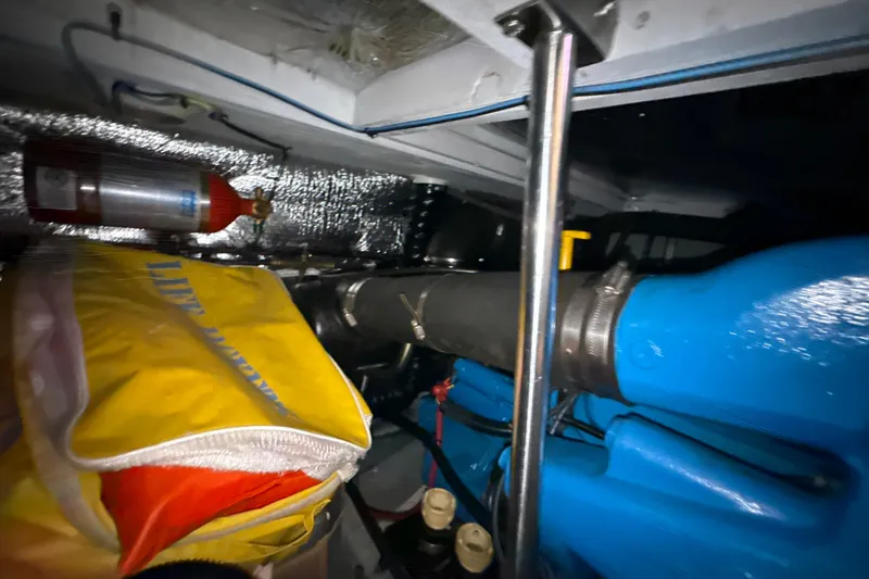 Slide: The Image of Engine room of 1999 Silverton 422 Motor Yacht with safety equipment and blue engine components. - 82