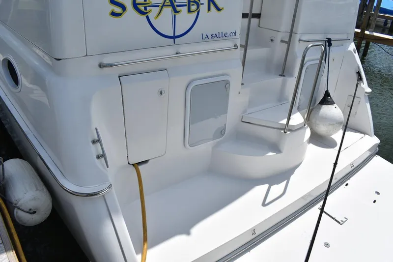 Slide: The Image of 1999 Silverton 422 Motor Yacht stern view with steps and docked fender. - 9