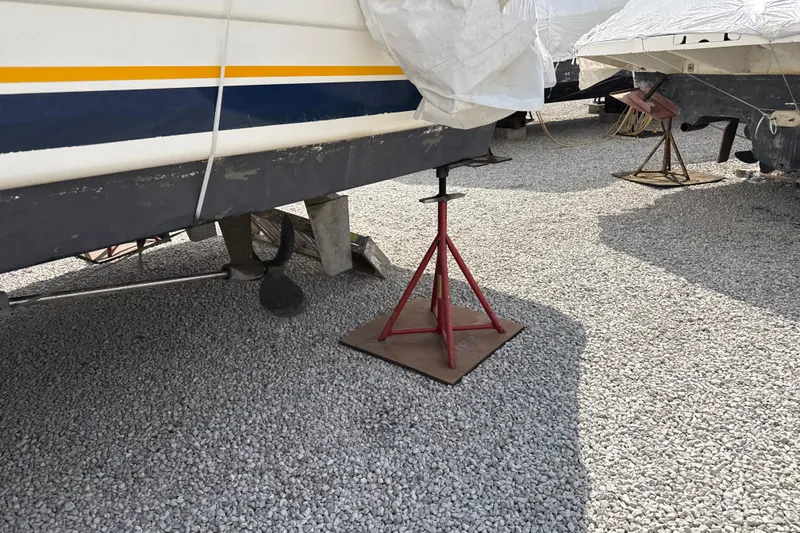 Slide: The Image of 1999 Silverton 422 Motor Yacht on stands, gravel surface, under maintenance. - 93