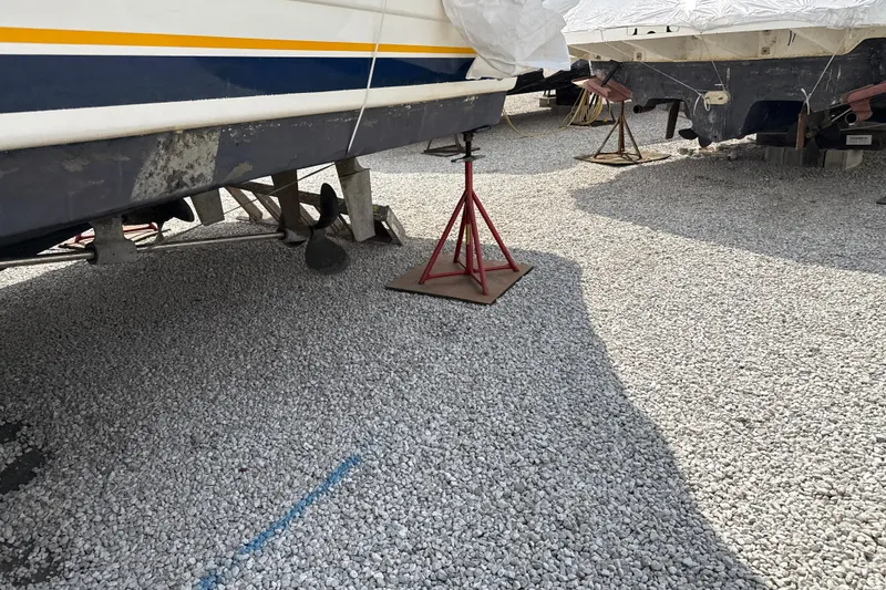 Slide: The Image of 1999 Silverton 422 Motor Yacht on stands, gravel ground, boat maintenance area. - 94