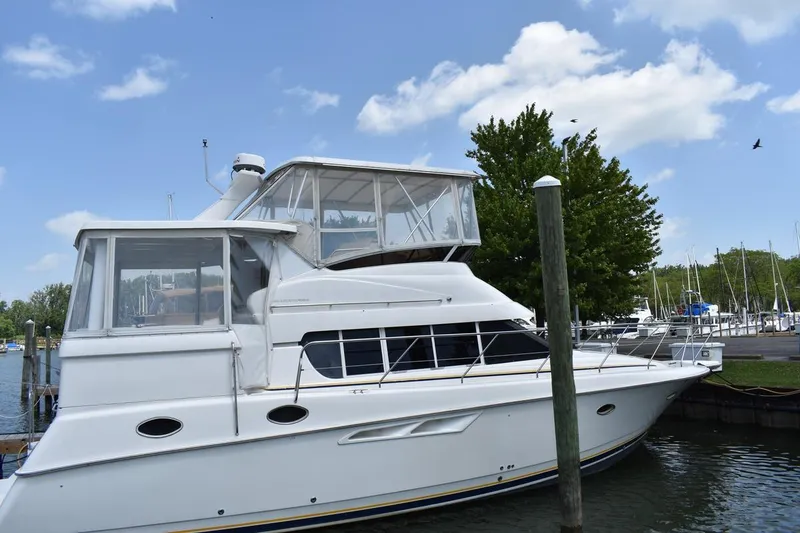 Slide: The Image of 1999 Silverton 422 Motor Yacht docked at marina under blue sky. - 12