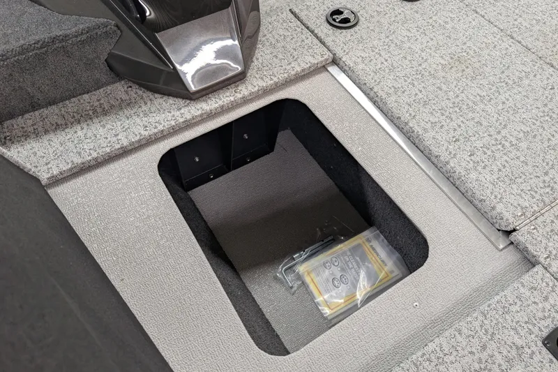 Slide: The Image of 2026 Smoker Craft Viper XR 165 boat storage compartment with gray carpeted interior. - 10