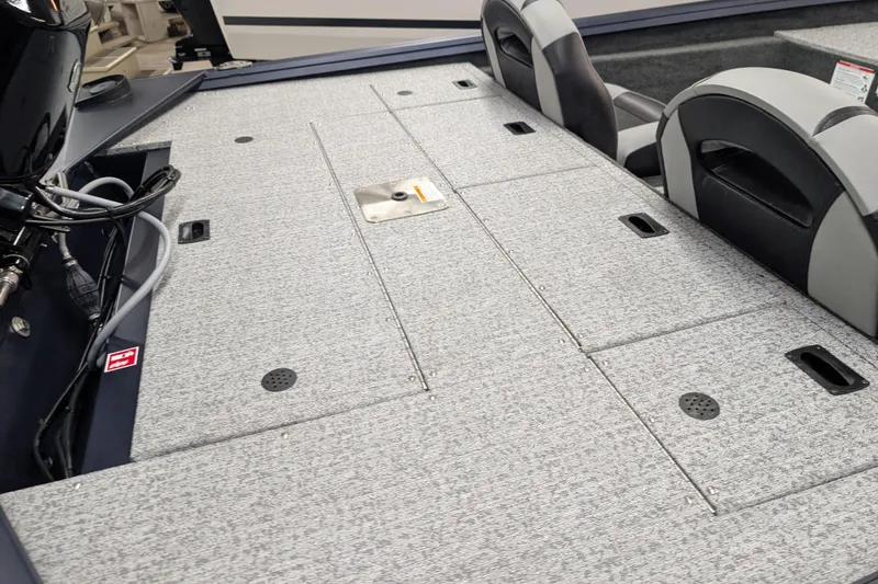 Slide: The Image of 2026 Smoker Craft Viper XR 165 boat interior with gray carpeted deck and seating. - 4