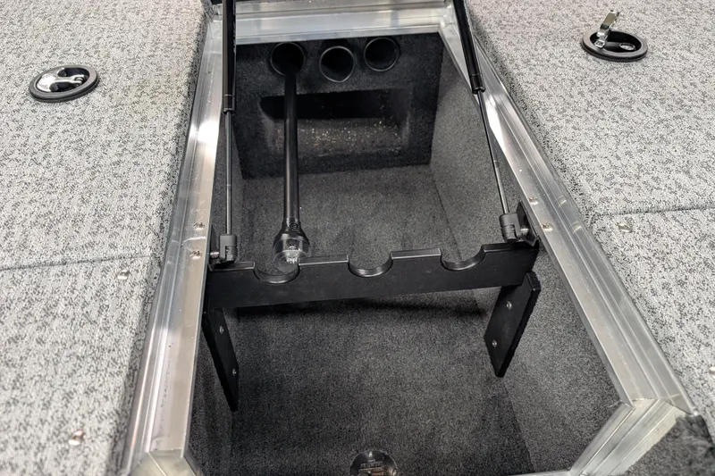 Slide: The Image of 2026 Smoker Craft Viper XR 165 boat storage compartment with rod holders and carpeted interior. - 8