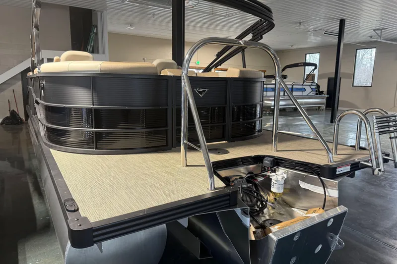 Slide: The Image of 2026 Manitou 23 AURORA RF VPII 575 pontoon boat in showroom, rear view. - 3