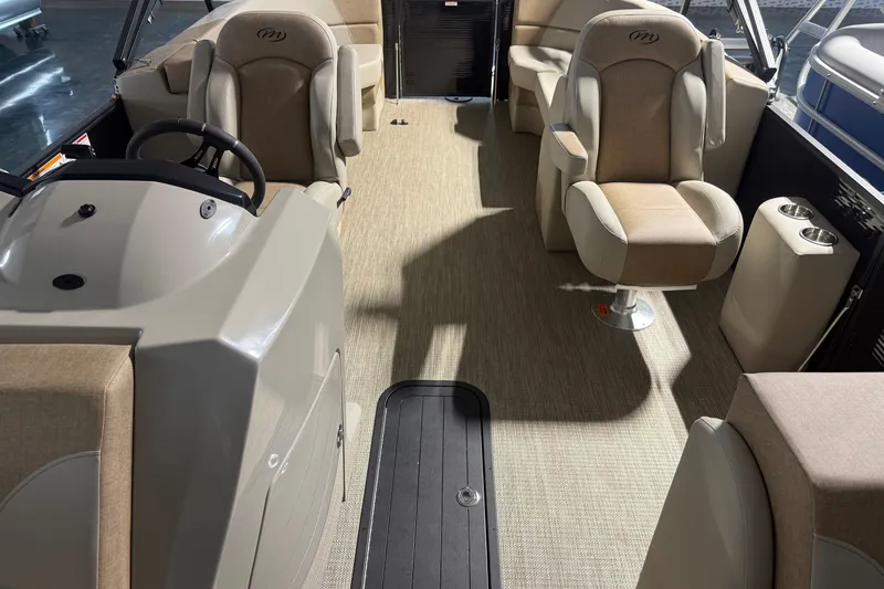 Slide: The Image of Interior of 2026 Manitou 23 AURORA RF VPII 575 boat with beige seating and steering console. - 7
