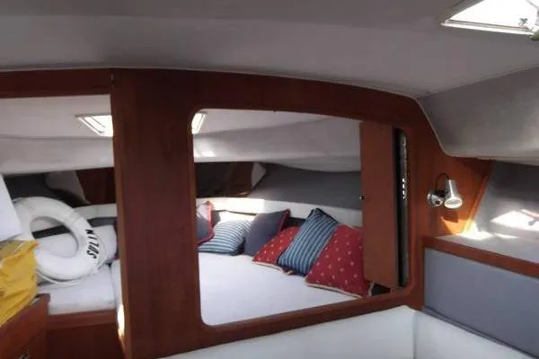 Slide: The Image of Interior of 1989 Tiara Yachts 3100 Open, featuring cozy cabin with pillows and wooden accents. - 10