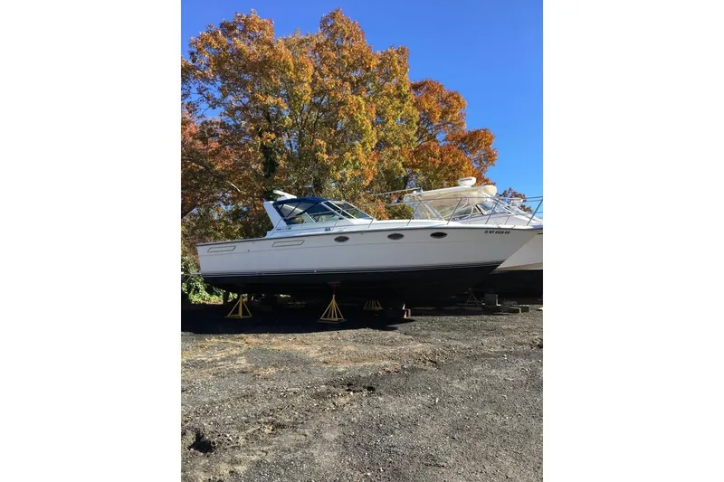 Slide: The Image of 1989 Tiara Yachts 3100 Open boat on stands, autumn trees in background. - 2