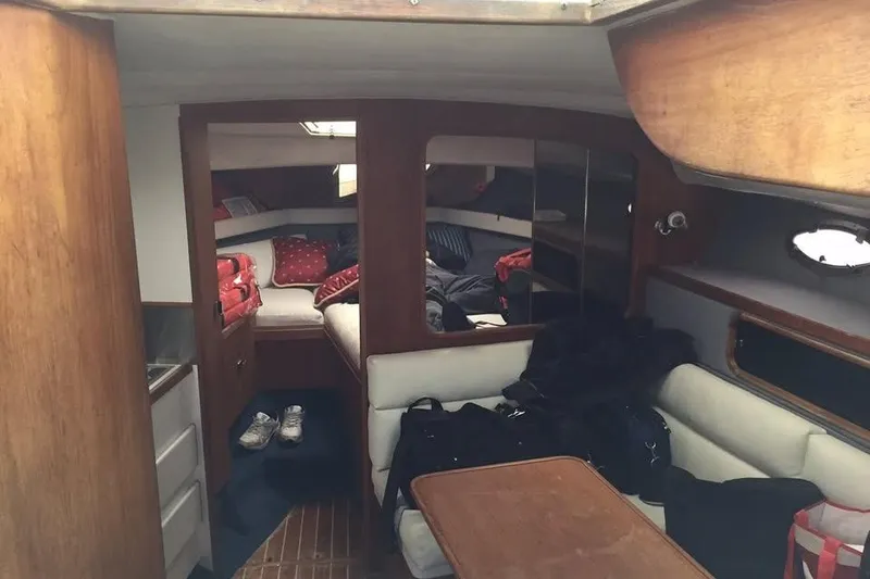 Slide: The Image of Interior of 1989 Tiara Yachts 3100 Open, featuring cozy cabin and seating area. - 4