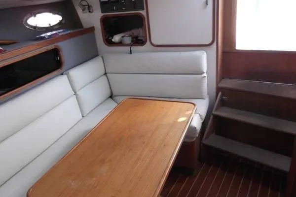 Slide: The Image of 1989 Tiara Yachts 3100 Open cabin interior with seating and wooden table. - 6