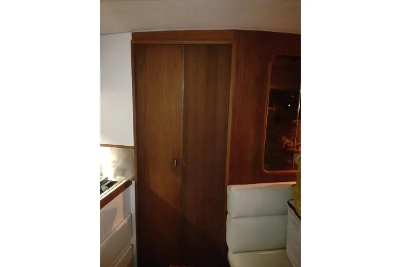 Slide: The Image of Interior of 1989 Tiara Yachts 3100 Open, featuring wooden cabinetry and seating. - 7