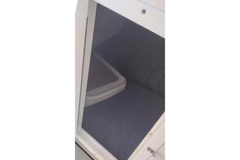 Slide: The Image of Storage compartment inside 2023 Yamaha AR250 boat, featuring carpeted interior. - 20