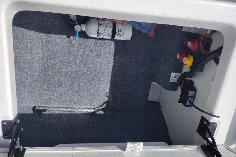 Slide: The Image of Storage compartment of 2023 Yamaha AR250 boat with fire extinguisher and wiring. - 26