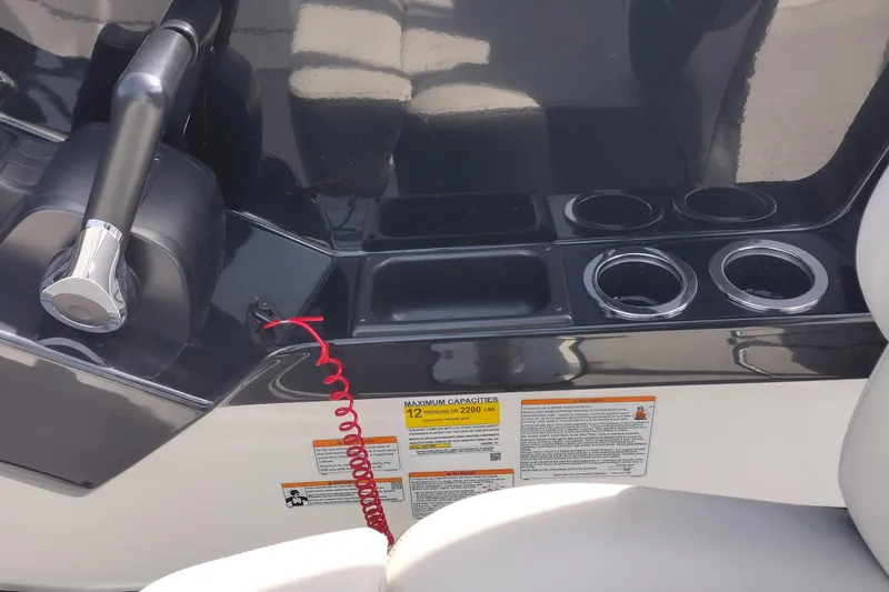 Slide: The Image of 2023 Yamaha AR250 boat console with throttle, cup holders, and safety instructions. - 27