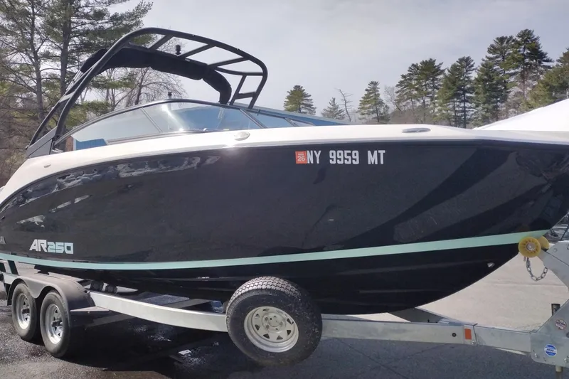 Slide: The Image of 2023 Yamaha AR250 boat on trailer, parked outdoors with trees in background. - 3
